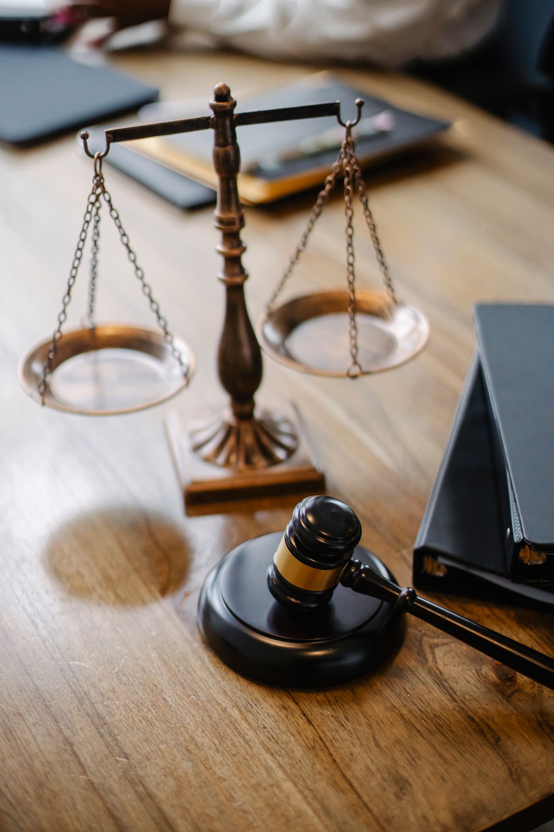 Balança da Justiça, martelo e livros jurídicos sobre uma mesa